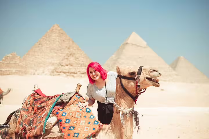 Tourist with camel at Giza Pyramids, Egypt, enjoying a daytime camel ride desert tour photo stop