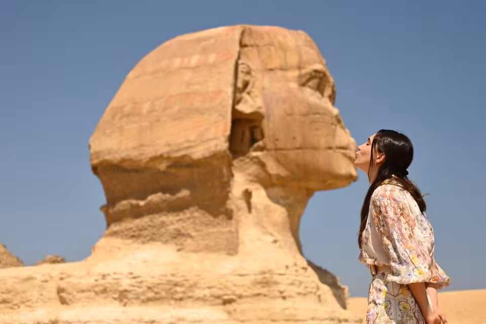 Tourist posing by the Great Sphinx of Giza on Cairo day tour to Pyramids, Memphis City, Sakkara and Dahshur