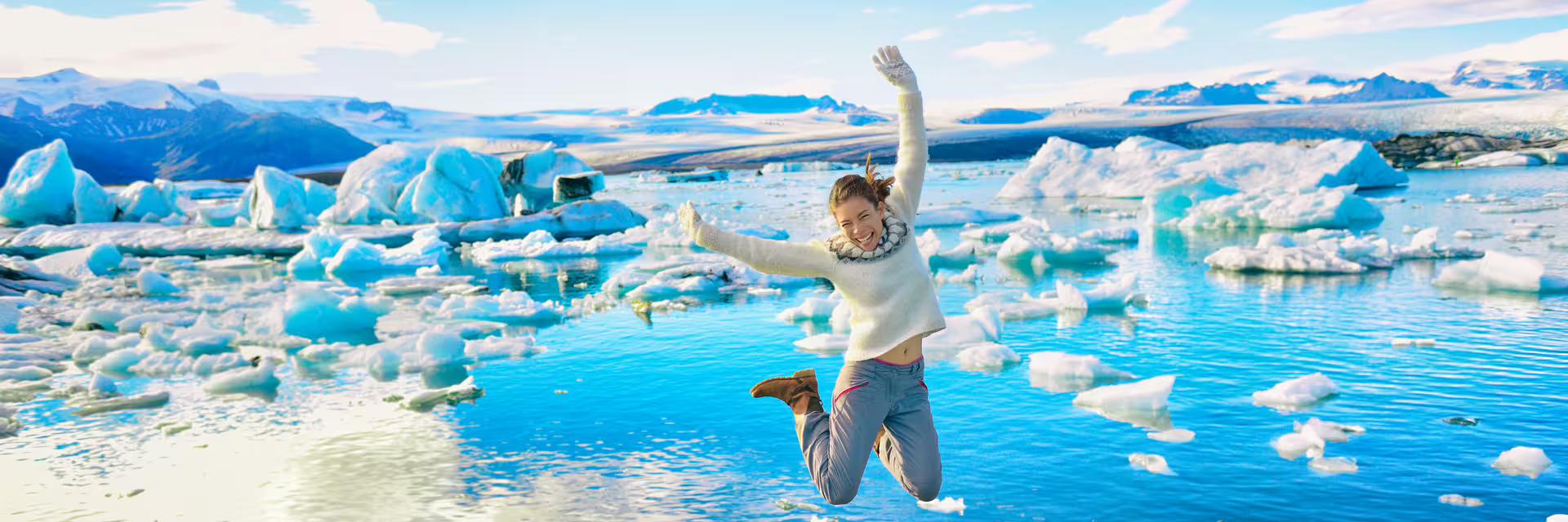 A tourist jumping in joy at Jokulsarlon in Iceland