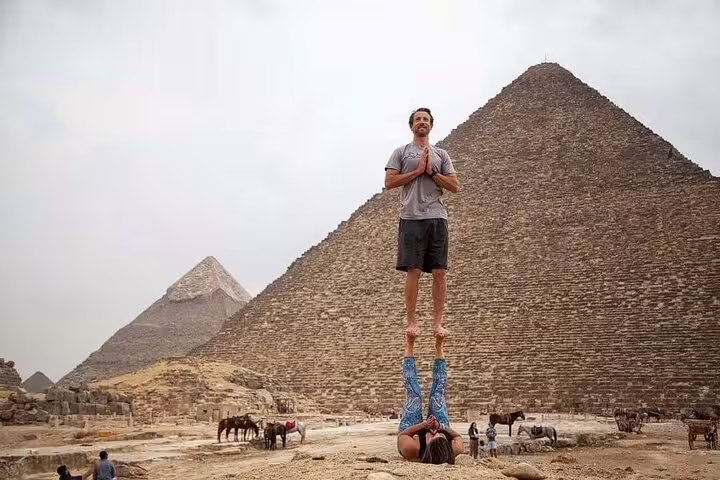 Tourists doing an acro pose in front of the Great Pyramid of Giza on a Cairo pyramids and museum tour