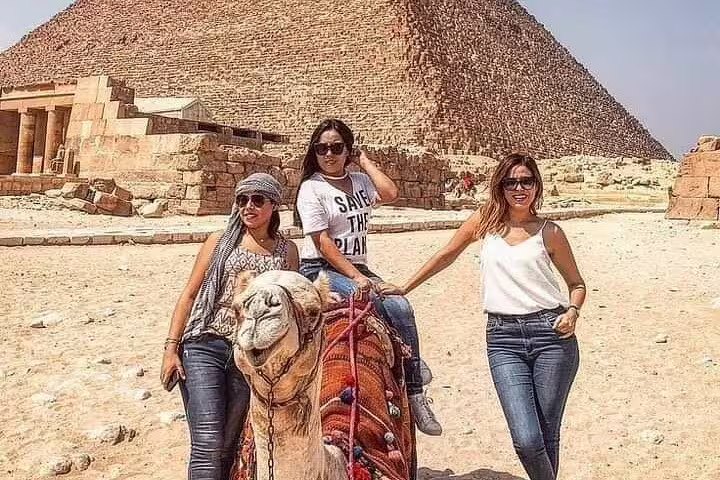 Tourists on camel ride at the Giza Pyramids complex, private 3-hour tour photo stop in Cairo