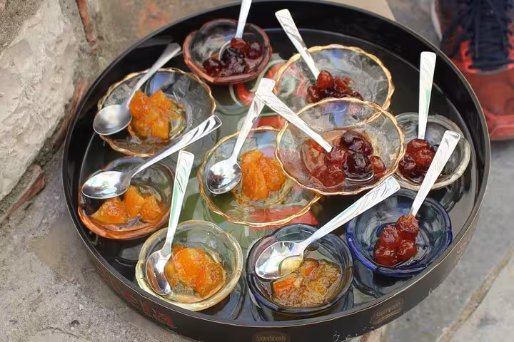 Assorted traditional Albanian preserves and jams in small glass dishes, showcased at a Berat cooking class.