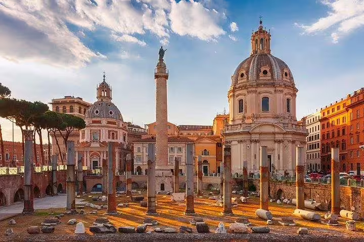 Trajan’s Column and church domes in Rome’s Imperial Forum district at sunset, seen on a guided skip-the-line tour