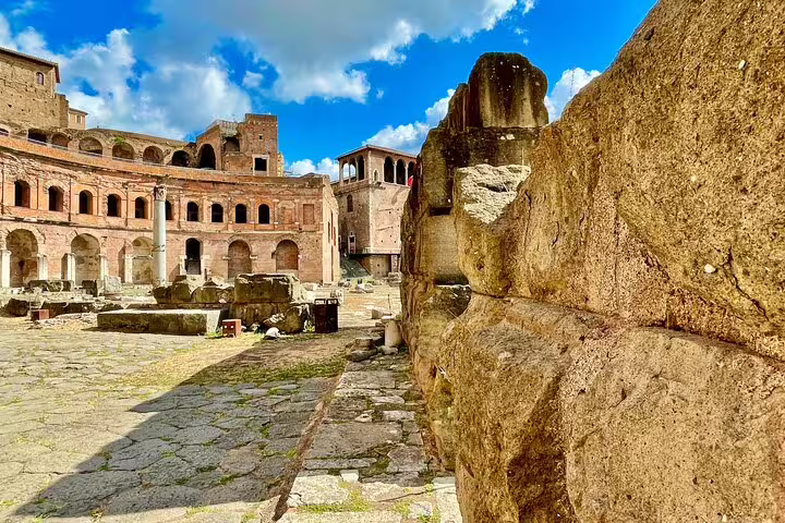 Ancient stone walls and ruins of Trajan’s Markets in Rome under blue skies, explored on a private skip-the-line tour