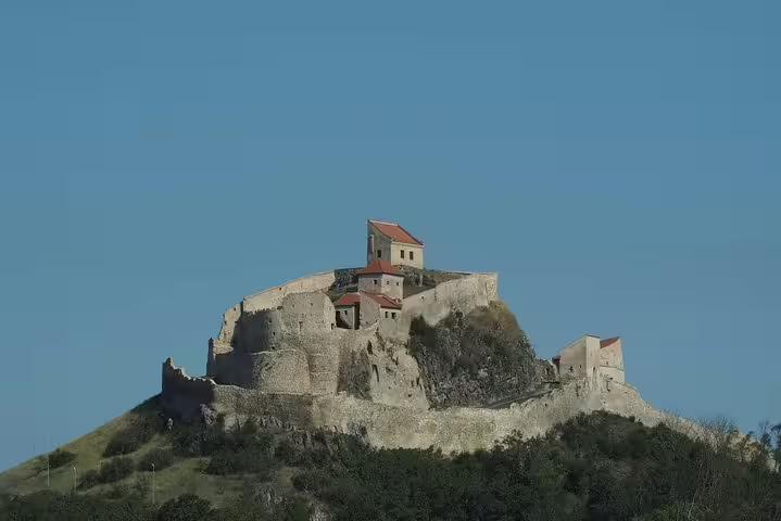 Medieval hilltop fortress ruins under blue sky in Transylvania, Romania