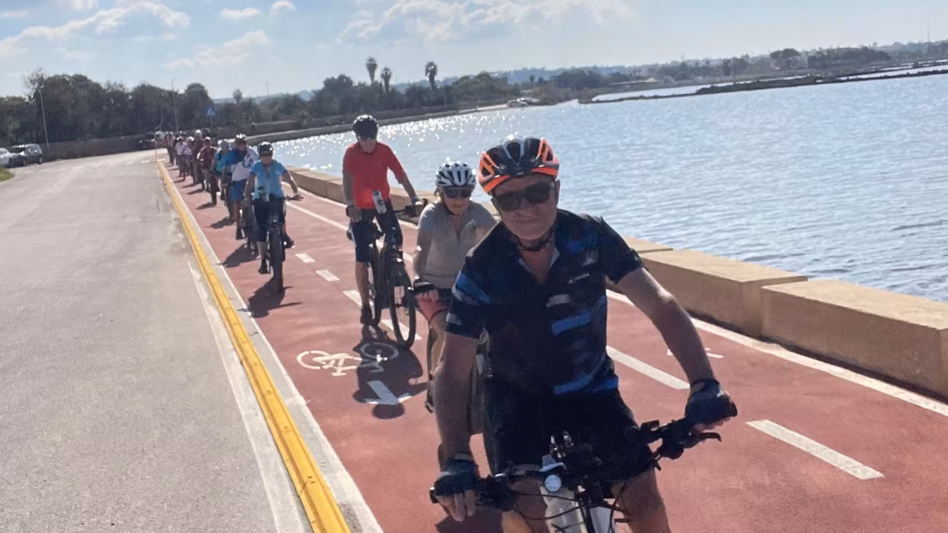Cyclists enjoy an ebike tour along the scenic Trapani coastline towards Marsala, with sparkling sea views.
