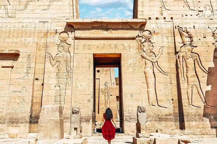 Traveler at Edfu Temple entrance, key stop on Overnight Luxor from Aswan tour via Kom Ombo and Edfu