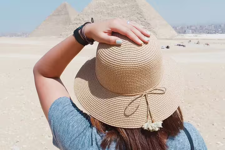 Traveler in sunhat facing Giza pyramids, premium Cairo tour to Memphis, Sakkara and Dahshur
