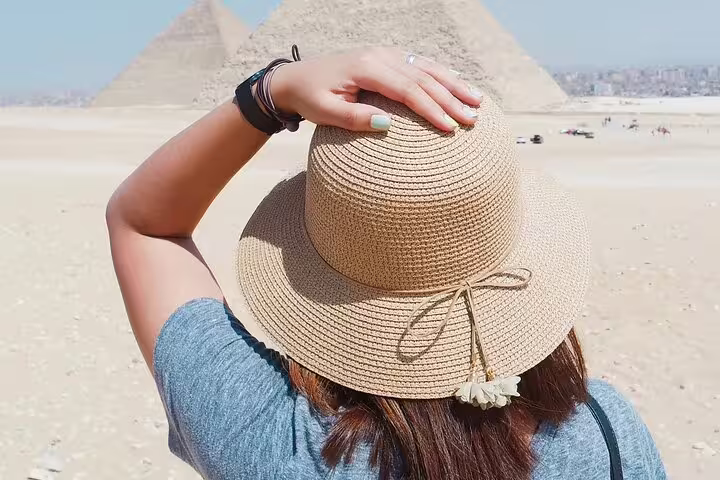 Traveler in sun hat overlooking Giza Pyramids on private Cairo tour with museum visit and no hidden costs