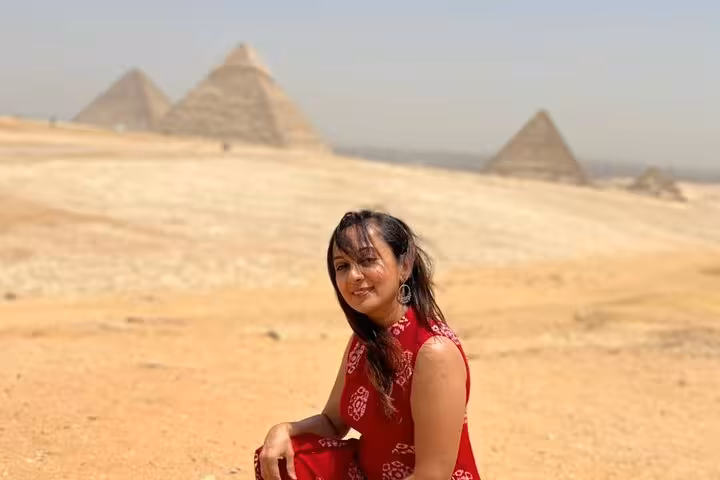 Traveler in desert with Giza Pyramids backdrop, ideal for private pyramids and Sphinx adventure with camel ride