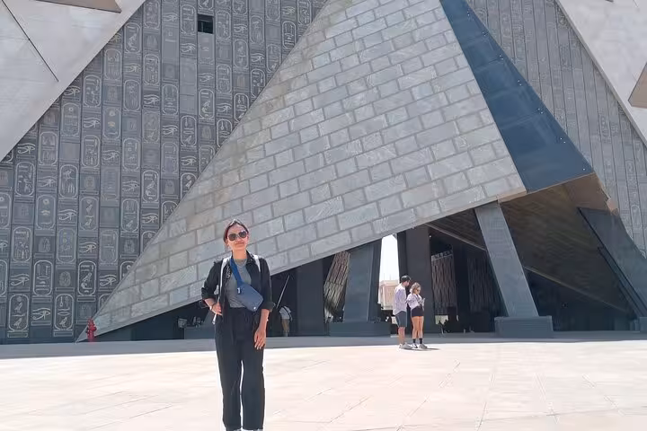 Traveler at Grand Egyptian Museum entrance in Giza on private Cairo tour with Citadel and Khan El Khalili