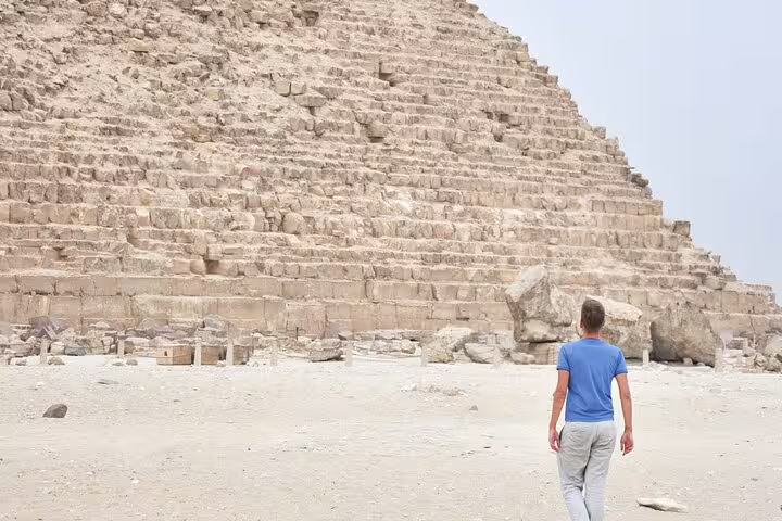 Traveler walking beside the Great Pyramid of Giza on a 4-day Cairo and Red Sea tour package in Egypt