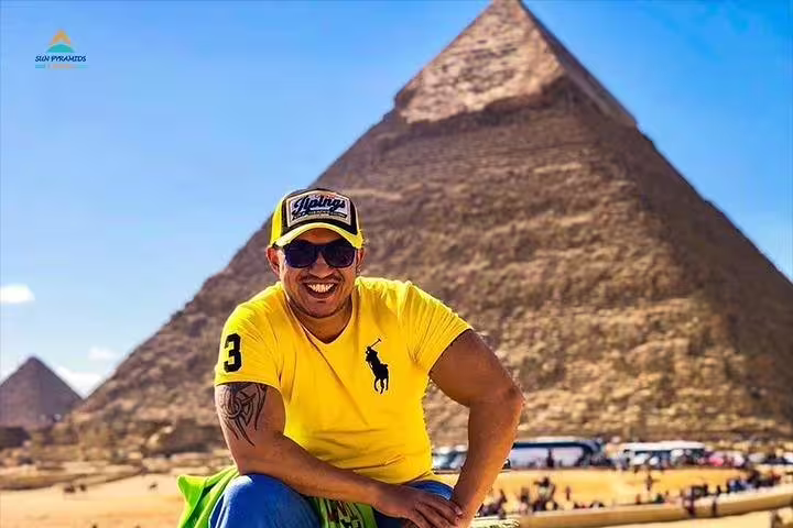 Smiling traveler at the Great Pyramid of Giza, highlight of a 2-day Alexandria to Cairo and Giza guided tour
