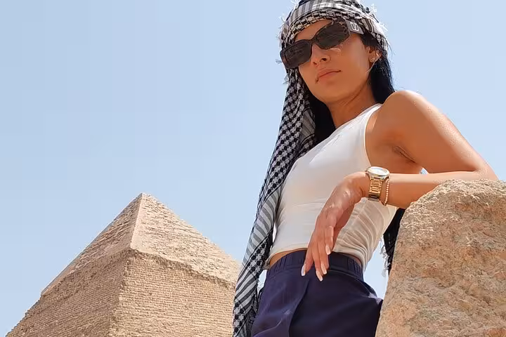 Traveler posing by the Great Pyramid of Giza on a half-day pyramids tour with 9-pyramids view stop