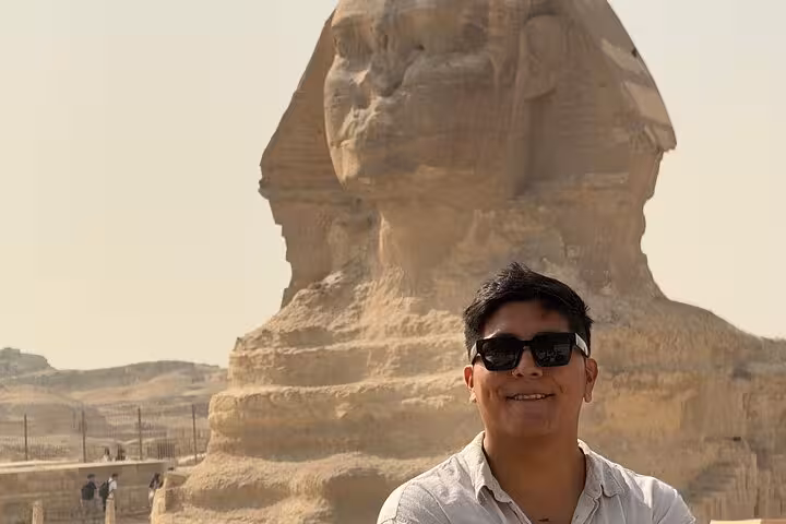 Smiling traveler with the Great Sphinx of Giza backdrop on half-day pyramids tour, Cairo sightseeing photo