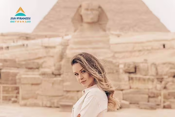 Traveler poses by the Great Sphinx and Giza Pyramids on a Cairo half-day horse carriage tour experience