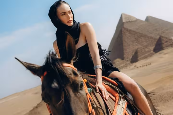 Traveler riding a horse near Giza Pyramids, scenic half-day pyramids tour with 9-pyramids view backdrop