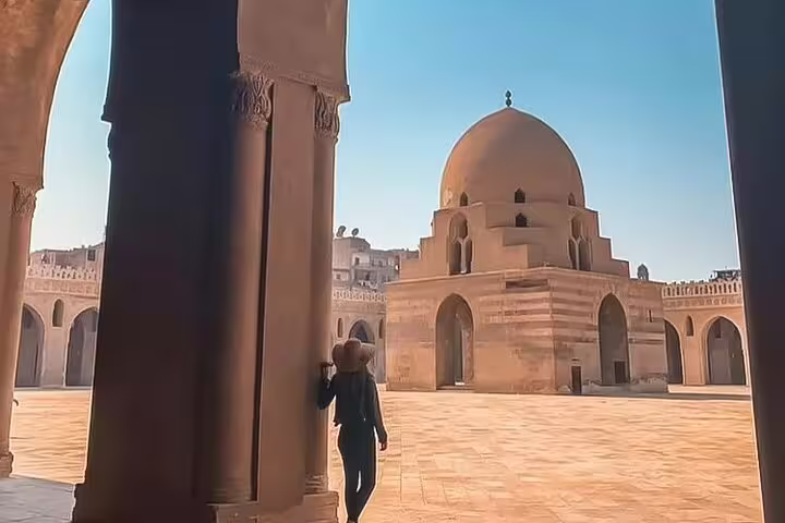 Traveler walking in Ibn Tulun Mosque courtyard in Islamic Cairo, part of Alexandria Port shore excursion to Old Cairo