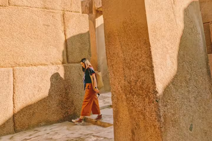 Traveler walking among massive limestone blocks at Memphis ruins, Pyramids and Saqqara full-day tour