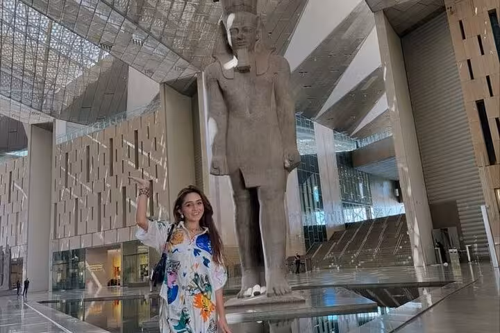 Traveler posing by the colossal Ramses II statue inside the Grand Egyptian Museum Cairo half-day tour