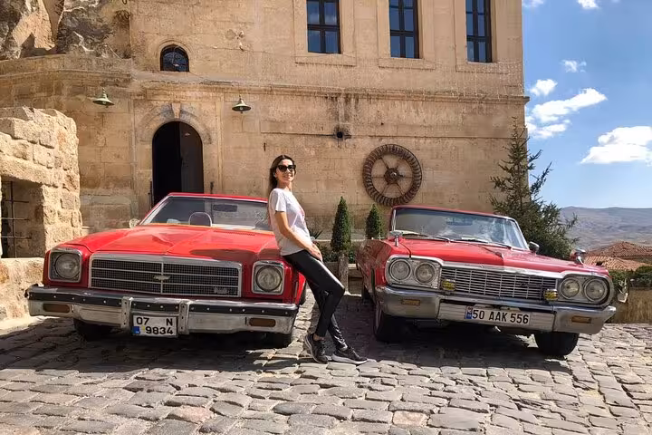 Traveler with classic red cars in Cappadocia, Turkey on 6-day Istanbul Cappadocia tour in Spanish with flights