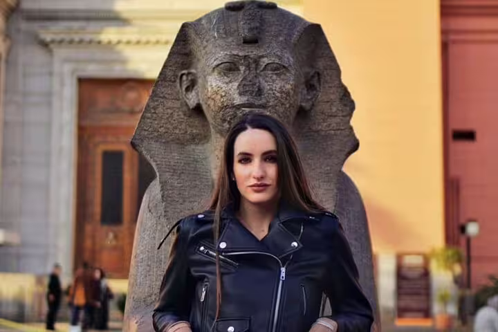 Traveler posing by ancient sphinx statue at Egyptian Museum Cairo, part of Citadel and Old Cairo day tour
