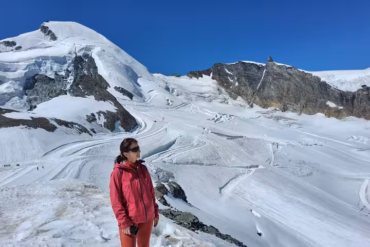 Traveler on snowy Swiss glacier viewpoint, Jungfrau Region alpine adventure on 4-day Zermatt Alps tour