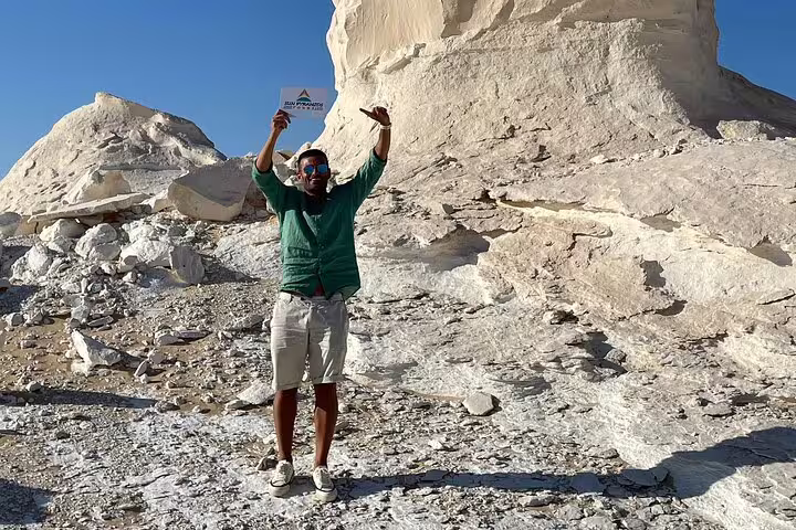 Traveler posing by chalk-white rock formations in Egypt’s White Desert on Bahariya Oasis camping tour