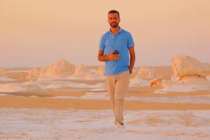 Traveler walking among chalk formations in Egypt’s White Desert on 3-day camping tour to Black Desert and Djara Cave