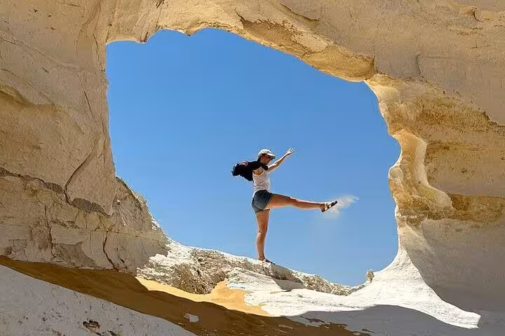 Traveler posing inside White Desert rock arch on 2-day private White & Black Desert tour from Cairo, Egypt