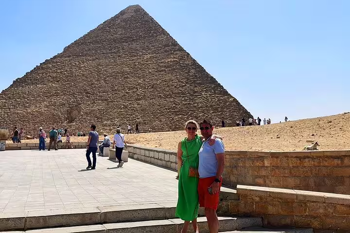 Travelers posing by the Great Pyramid of Giza on Memphis and Saqqara day tour with no extra cost
