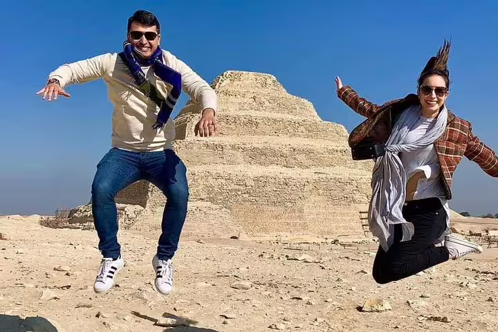 Travelers jumping by Sakkara Step Pyramid on Alexandria Port private tour with Giza Pyramids and camel ride