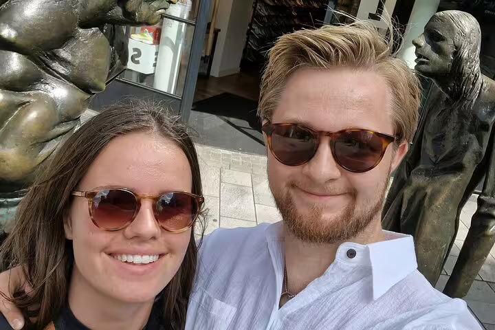 Travelers selfie by bronze statues on Düsseldorf scavenger hunt and sights self-guided walking tour downtown