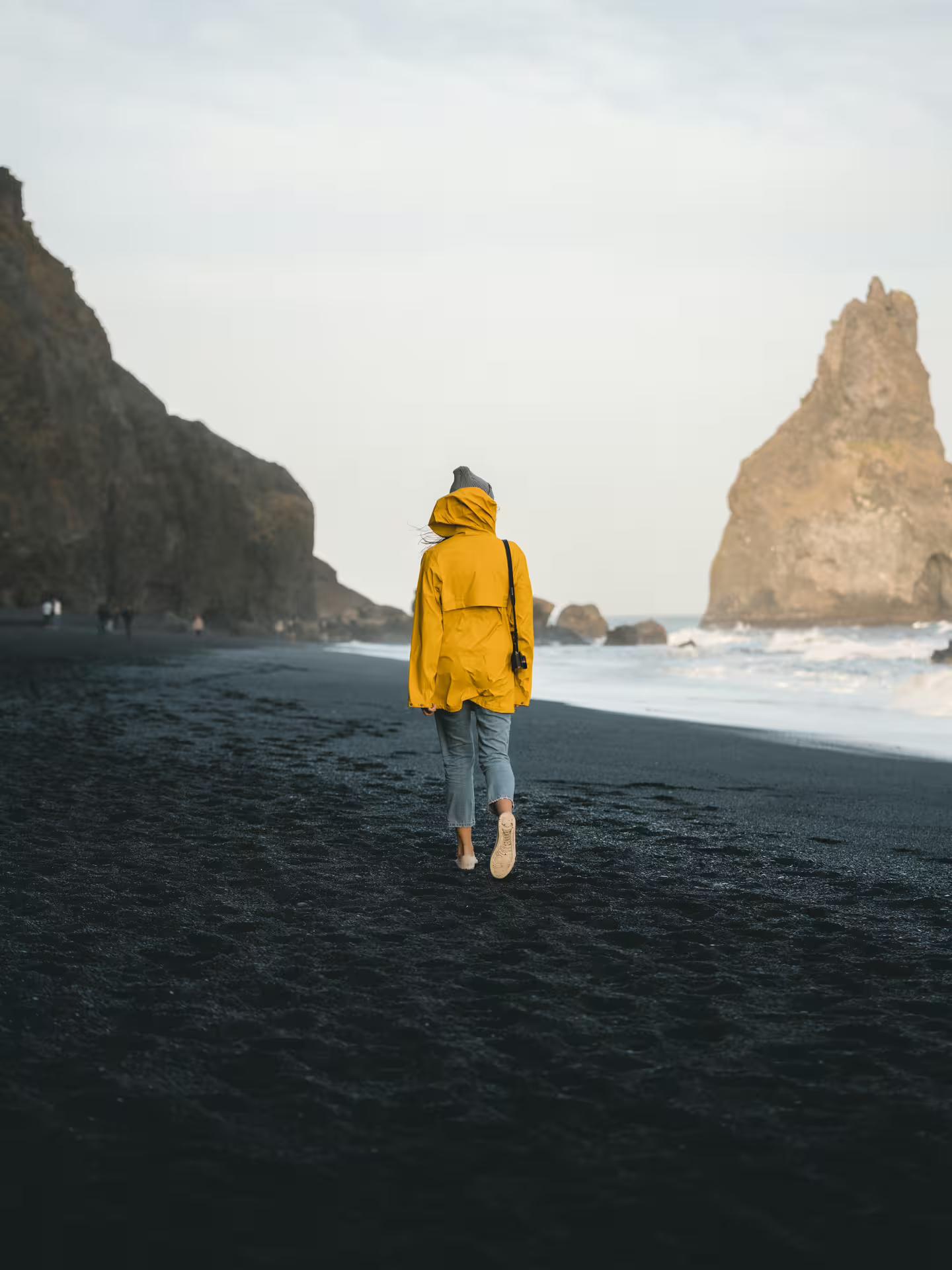 A traveller walking down Reynisfjara, the black beach in Iceland