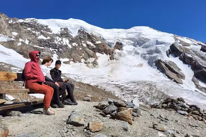 Trekkers resting by glacier viewpoint in the Swiss Alps during 4-day Swiss Magic through the Alps trekking tour