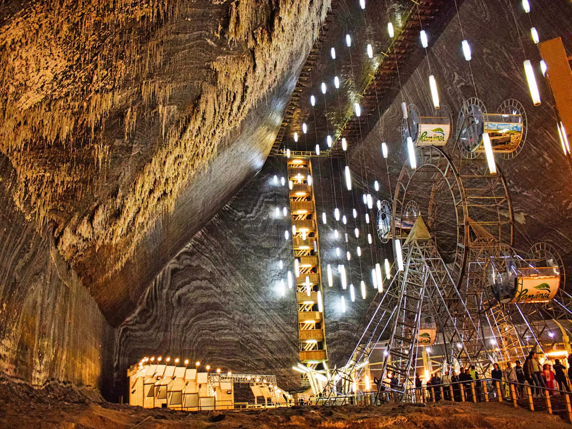 Stunning interior of Turda Salt Mine featuring a Ferris wheel and glowing lights inside massive salt caverns Romania