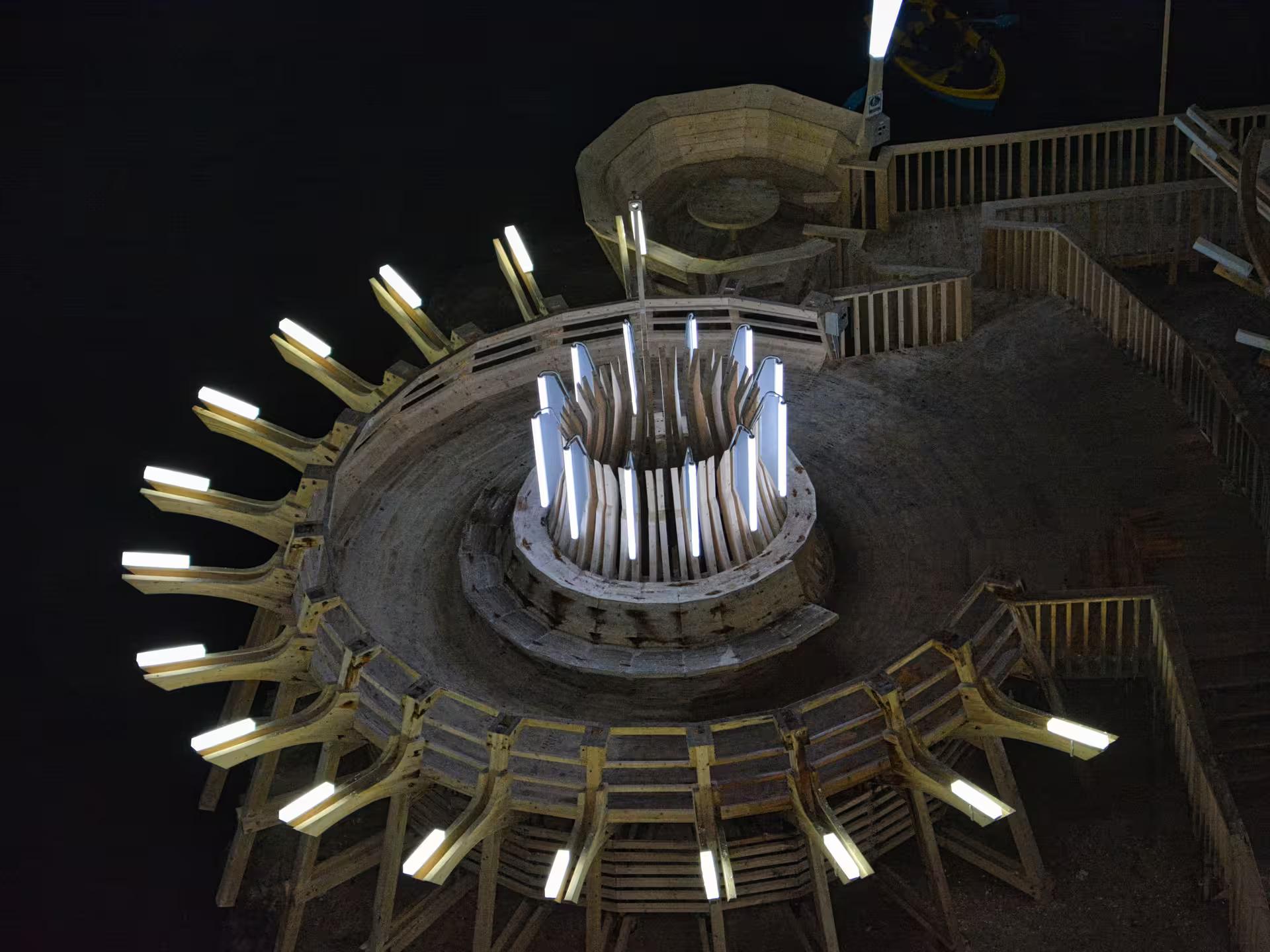 Stunning upward view of the illuminated wooden circular structure inside Turda Salt Mine on a Romania day tour