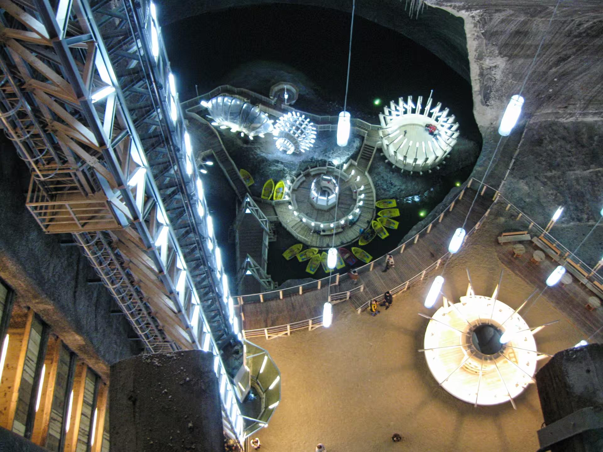 Aerial view of Turda Salt Mine underground amusement park with boats and lights on Transylvania guided tour