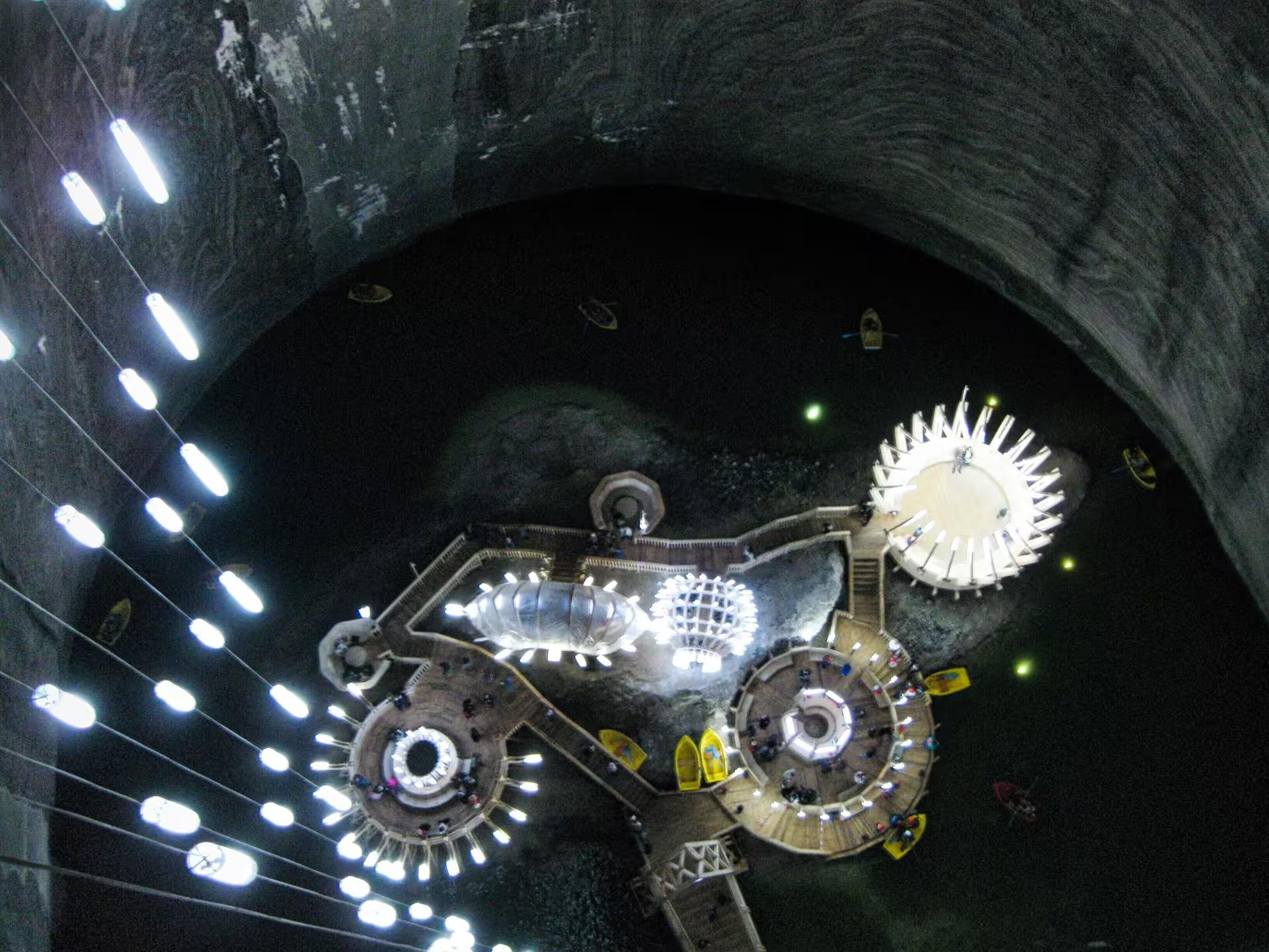 Aerial view of Turda Salt Mine underground amusement park with circular platforms and underground lake in Romania