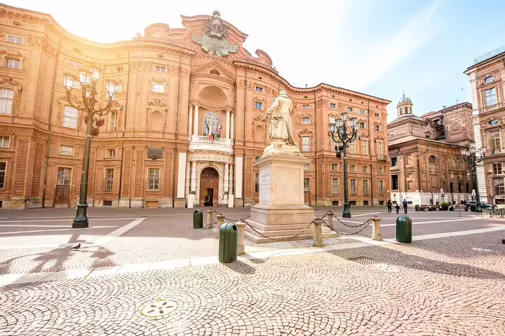 Sunlit Piazza Carlo Alberto in Turin with grand baroque palace façade and statue on a private guided walking tour route