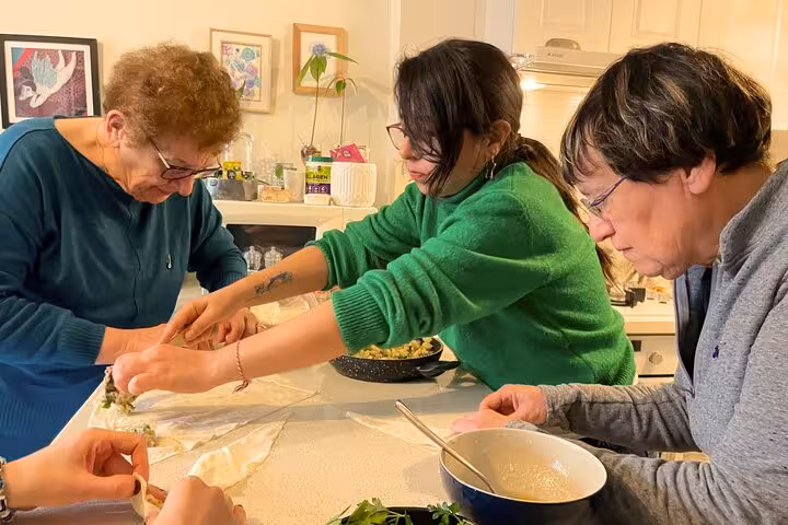Local host teaches guests to roll Turkish börek in a home kitchen during Istanbul city center cooking class