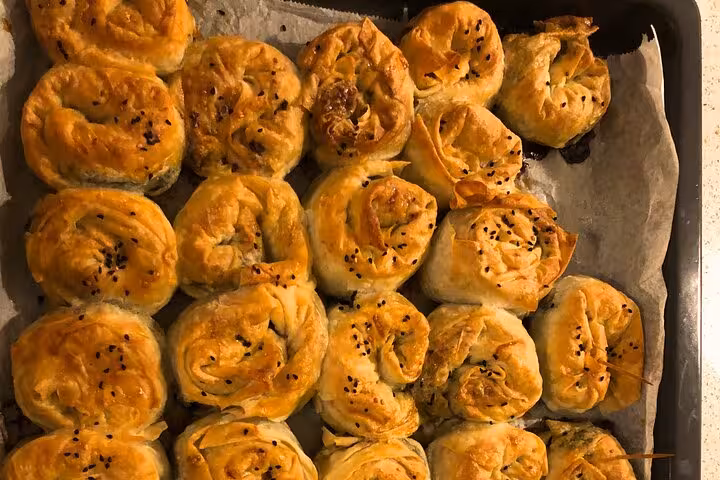 Freshly baked Turkish börek pastries on a tray, part of a traditional home cooking experience in Istanbul