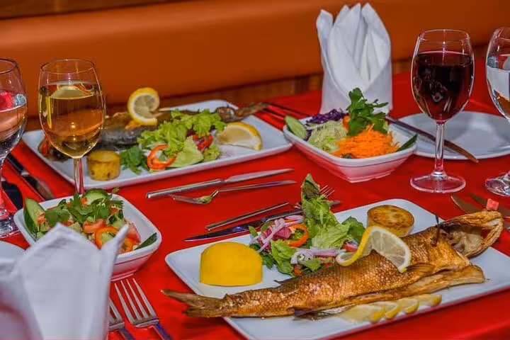 Dinner table with grilled fish, salads and wine on Turkish Night boat cruise with dinner and show