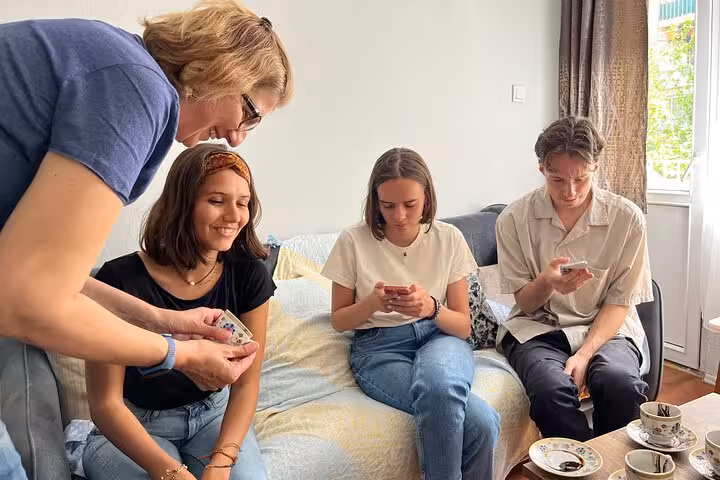Instructor demonstrates Turkish coffee tasting with guests in a cozy home-style cooking class experience