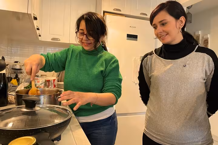 Hands-on Turkish cooking lesson with local host stirring pot in Istanbul city center home kitchen