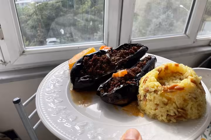 Plate of Turkish karniyarik stuffed eggplant with rice pilaf served in a local Istanbul home cooking class
