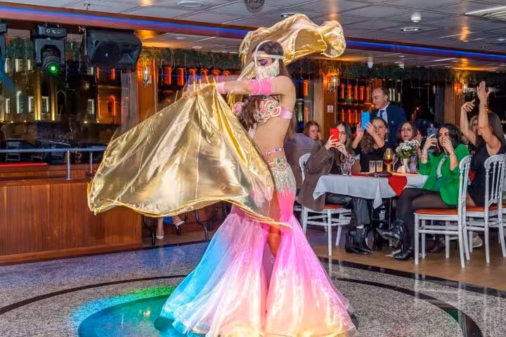 Belly dancer performing Turkish Night show on Bosphorus dinner cruise with guests dining in Istanbul