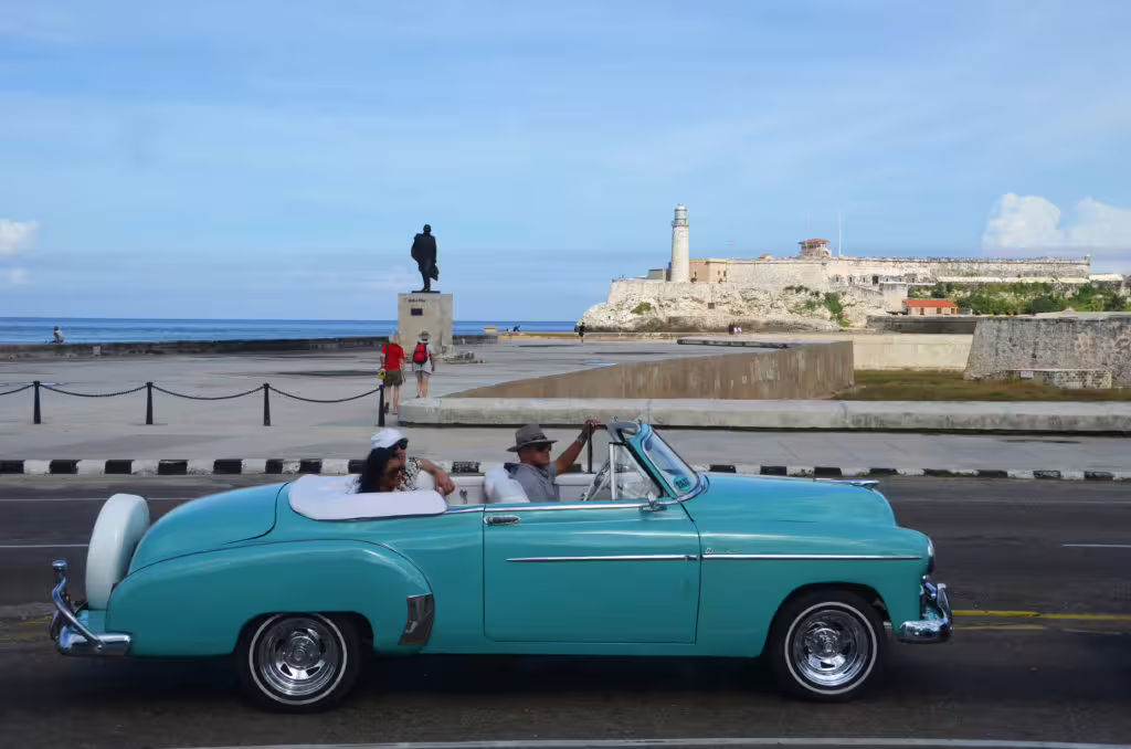Turquoise classic car by El Morro Fortress on the Malecon, 3-hour private Havana guided city tour