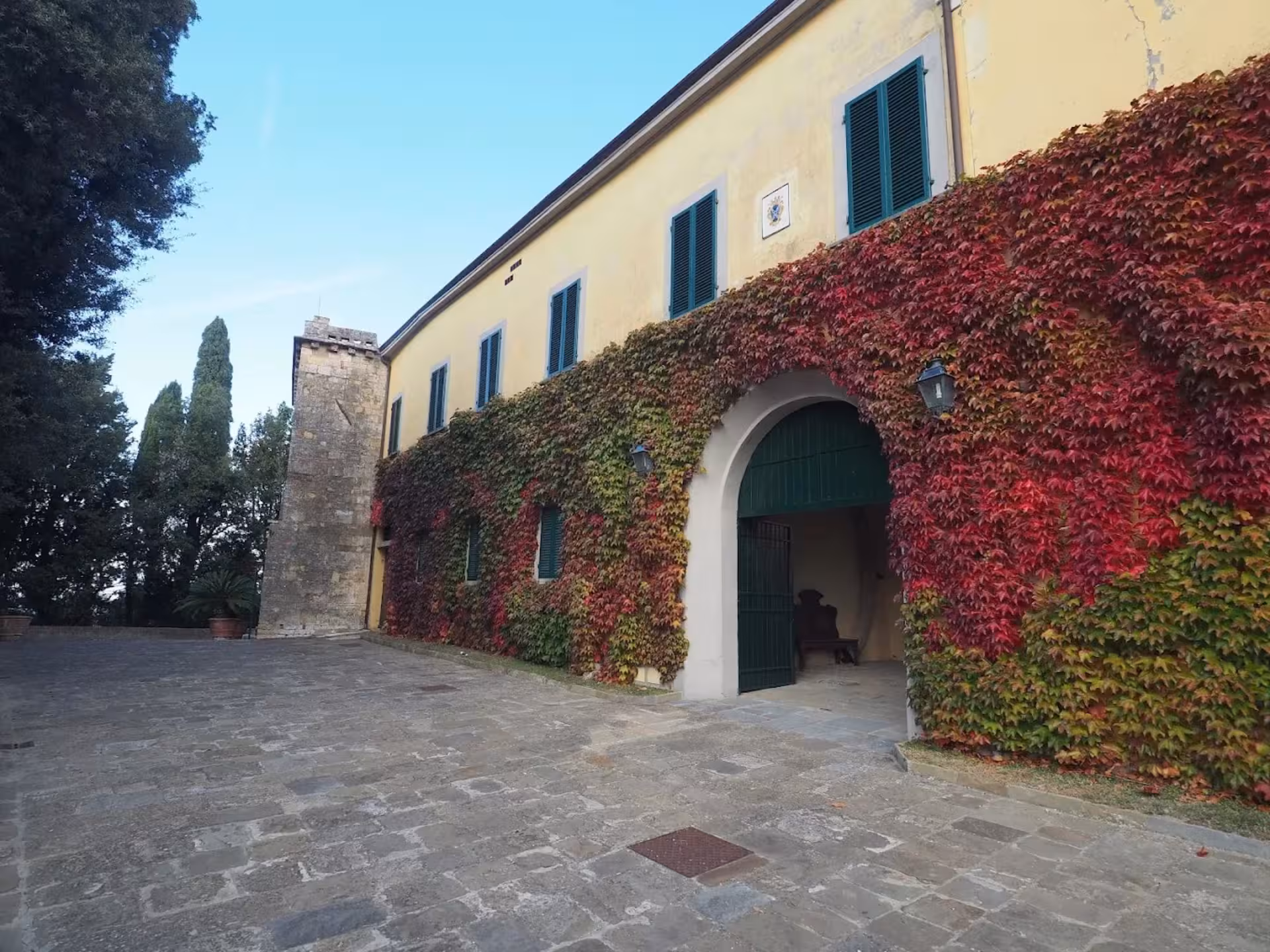 Explore a picturesque Tuscan estate with vibrant ivy-covered walls and classic architecture near Pisa.