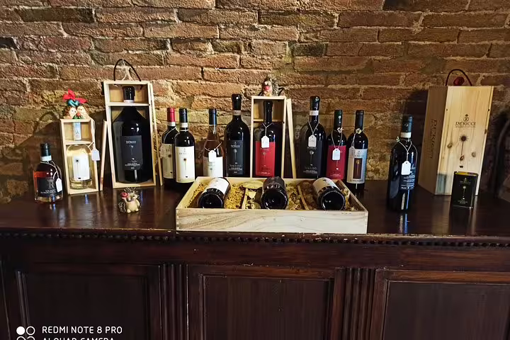 Selection of Tuscan red wines and gift boxes displayed in rustic Montepulciano tasting room on Cortona wine tour